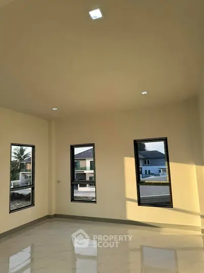 Spacious room with large windows and natural light, ideal for modern living.