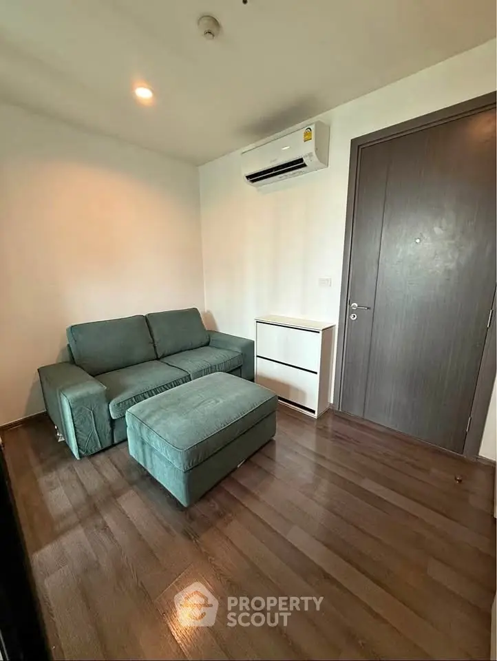 Cozy living room with modern sofa and air conditioning, perfect for relaxation.