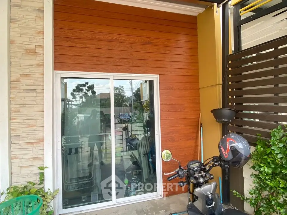 Modern exterior with sliding glass door and wooden paneling