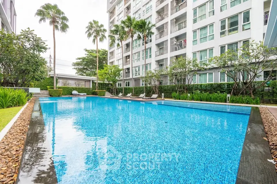 Luxurious condominium pool area with lush greenery and modern design.