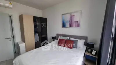 Cozy bedroom with modern decor and ample natural light, featuring a comfortable bed and stylish wardrobe.
