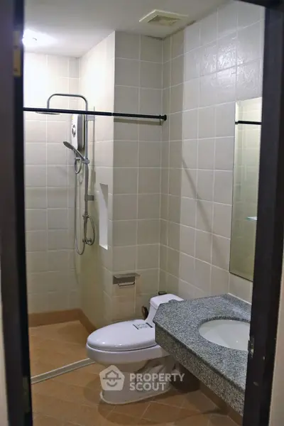 Modern bathroom with shower and granite countertop in a stylish apartment.