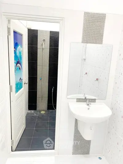 Modern bathroom with sleek fixtures and unique dolphin-themed door design.