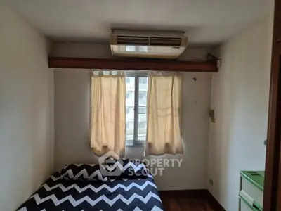 Cozy bedroom with air conditioning and natural light from window.
