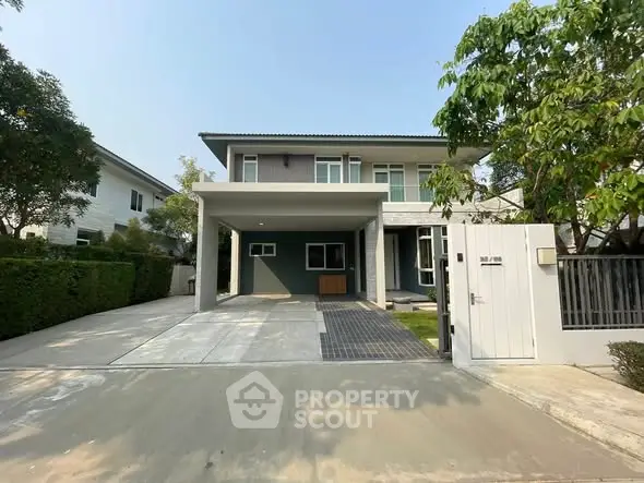Modern two-story house with spacious driveway and lush greenery