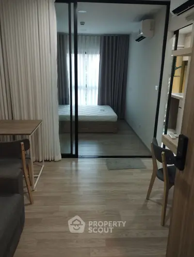 Modern apartment interior with glass partitioned bedroom and stylish furnishings.