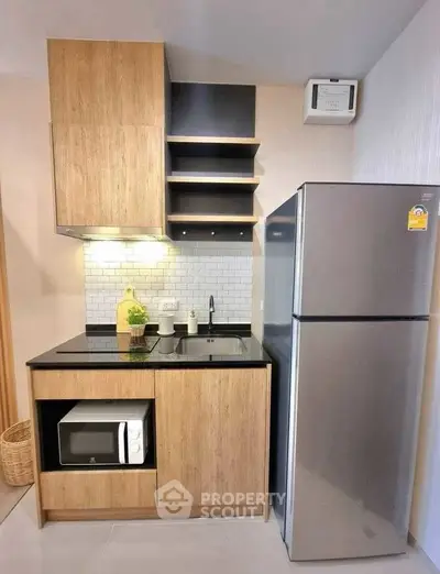 Modern compact kitchen with sleek appliances and wooden cabinetry