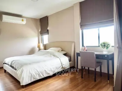 Elegant bedroom with modern decor, featuring a cozy bed and stylish desk by the window.