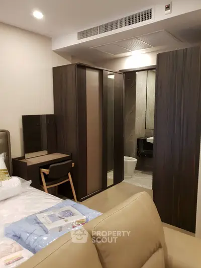 Modern bedroom with sleek furniture and ensuite bathroom in luxury apartment