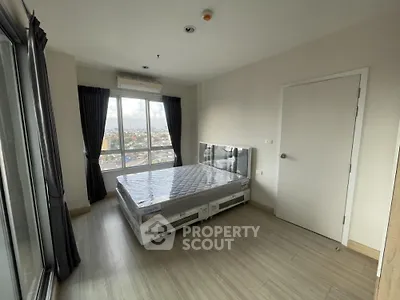 Modern bedroom with large window and city view in high-rise apartment