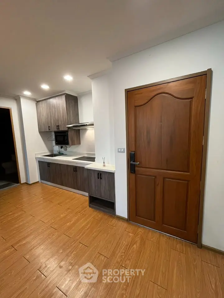 Modern kitchen with wooden flooring and sleek cabinetry