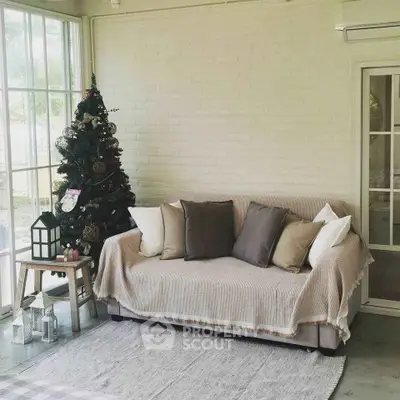 Cozy living room with sofa, Christmas tree, and large windows