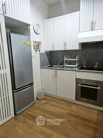 Modern kitchen with sleek appliances and wooden flooring