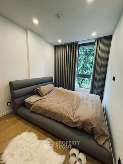 Cozy modern bedroom with plush bed and large window view