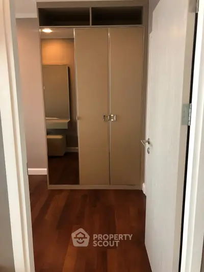 Elegant bedroom with wooden flooring and mirrored wardrobe
