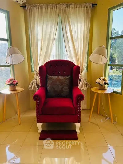 Elegant living room corner with plush red armchair and stylish decor