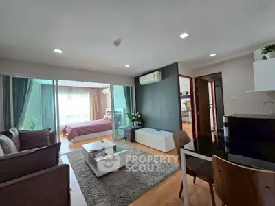 Modern open-plan living room with stylish decor and adjacent bedroom in a cozy apartment.