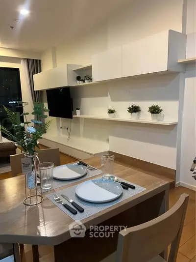 Modern dining area with stylish decor and open shelving in a cozy apartment setting.