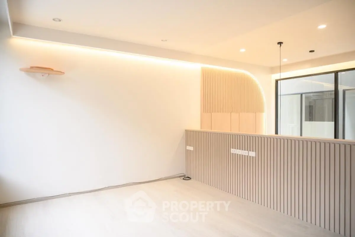 Modern minimalist living room with stylish lighting and wooden panel accents