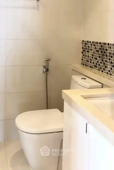 Modern bathroom with sleek design and mosaic tile accents.