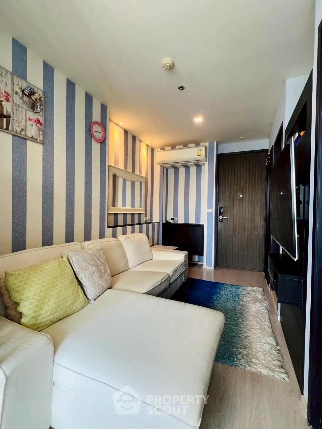 Chic modern living room with striped walls and cozy white sectional sofa