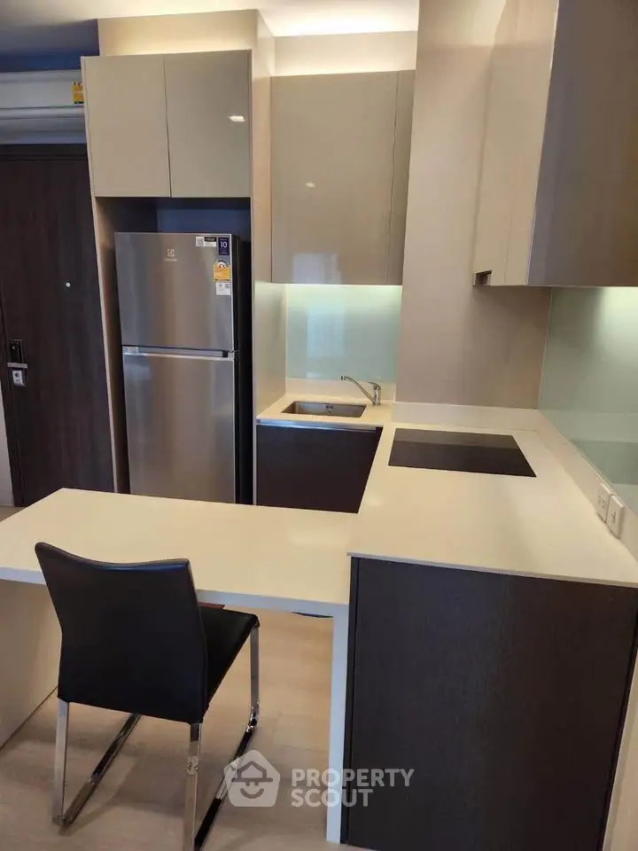 Modern kitchen with sleek design and integrated appliances in a compact layout.