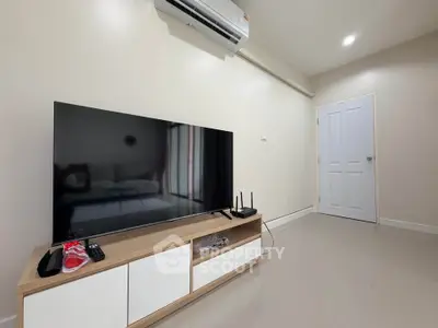 Modern living room with sleek TV setup and air conditioning
