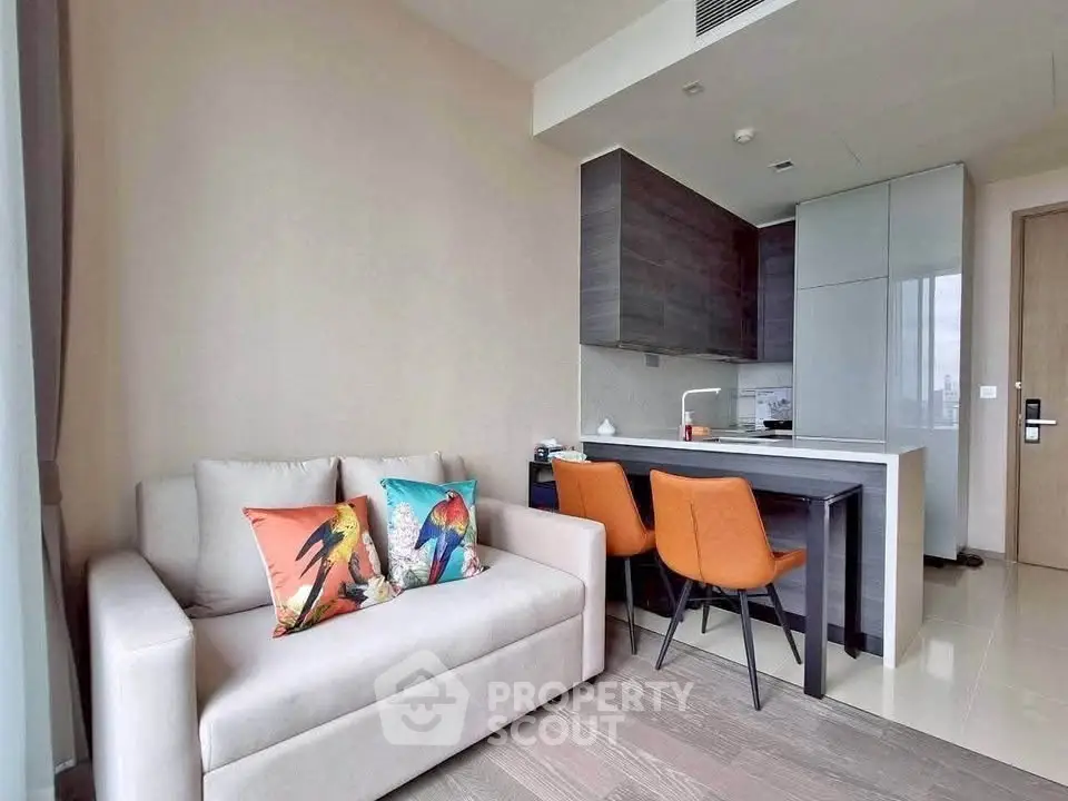 Modern living room with cozy sofa and stylish kitchen in open layout apartment.