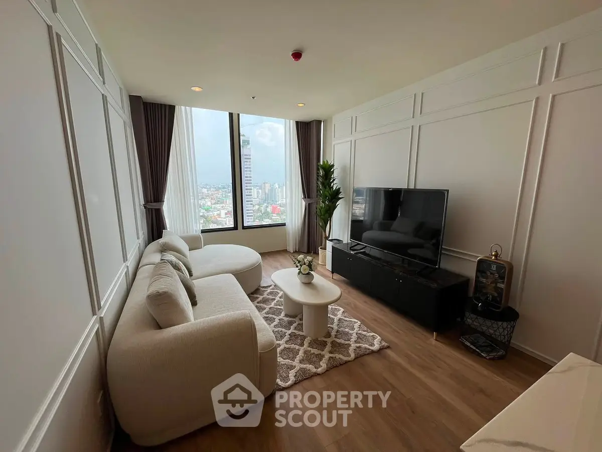 Modern living room with large window and city view, featuring elegant furniture and stylish decor.