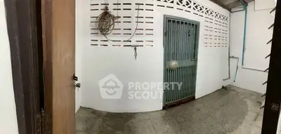 Simple storage area with metal door and concrete floor, ideal for utility use.