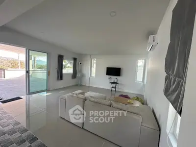 Spacious modern living room with large windows and balcony access