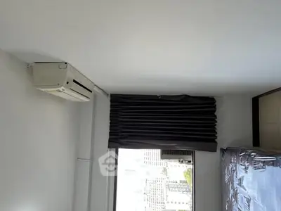 Modern bedroom with air conditioning and city view through window.