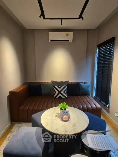 Cozy living room with modern sofa and air conditioning, perfect for relaxation.