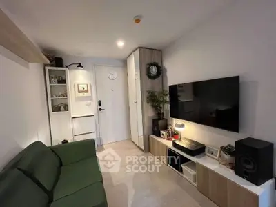 Modern living room with sleek furniture and wall-mounted TV in cozy apartment.