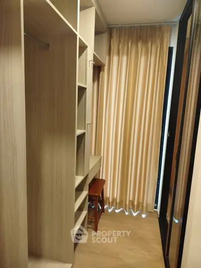 Spacious walk-in closet with wooden shelves and natural light
