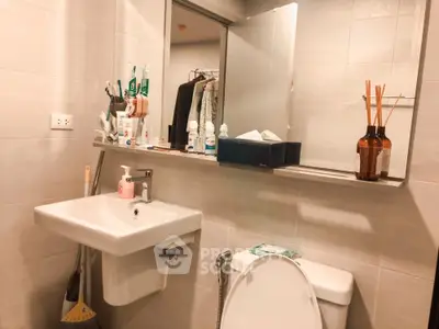 Modern bathroom with sleek sink and toilet, featuring stylish shelving and contemporary decor.