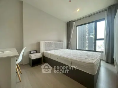 Modern bedroom with large window and minimalist decor in urban apartment