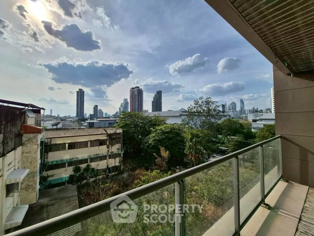 Stunning city view from a modern balcony with glass railing, perfect for urban living.