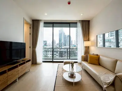 Modern living room with city view, featuring sleek furniture and large windows for natural light.