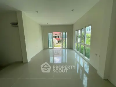 Spacious empty living room with large windows and garden view