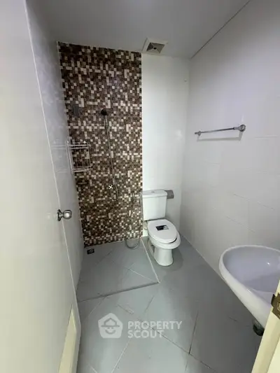 Modern bathroom with mosaic tile accent wall and sleek fixtures