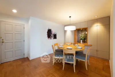 Elegant dining area with wooden flooring and modern lighting in a cozy apartment.