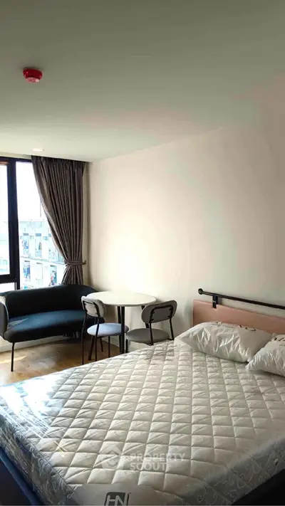 Modern bedroom with large window and cozy seating area