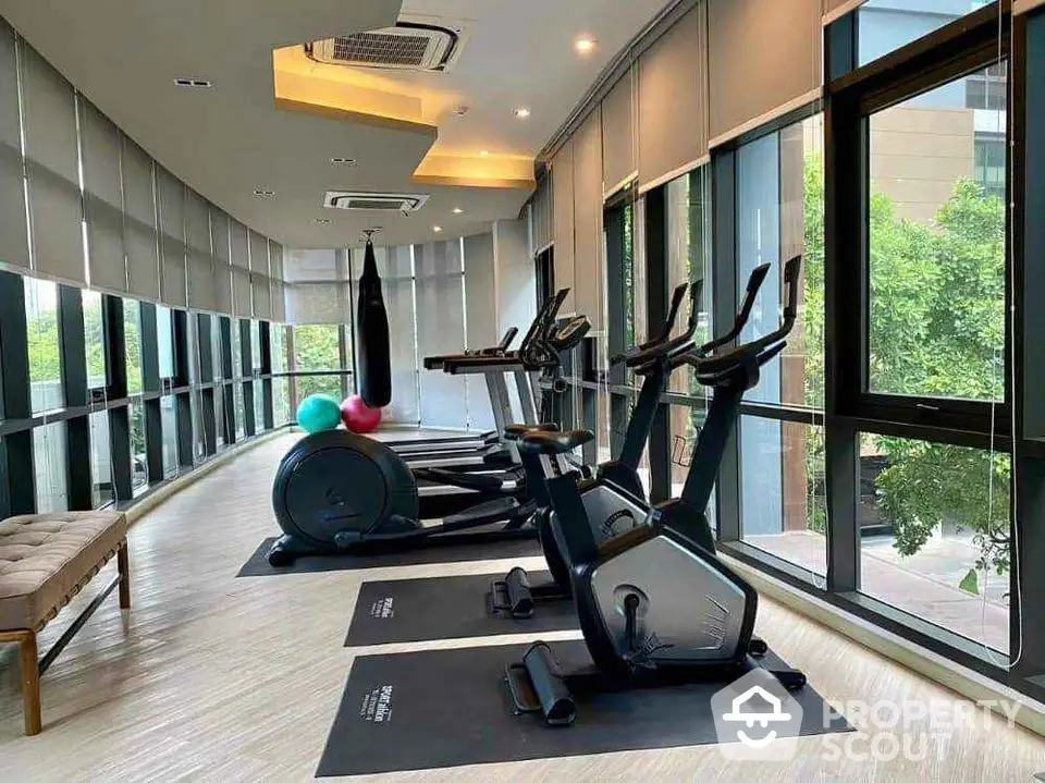 Modern gym with exercise equipment and large windows offering a scenic view