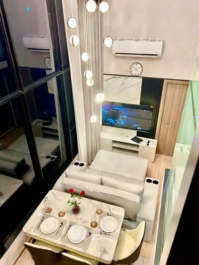 Luxurious modern living room with high ceilings, elegant dining setup, and stylish decor.