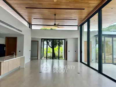 Spacious modern living room with high ceilings and large windows offering stunning views.