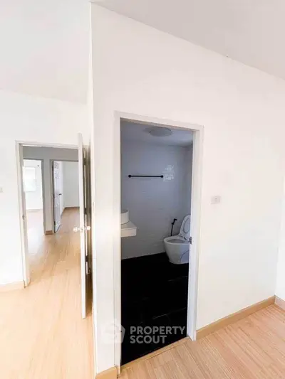Bright interior with wooden flooring and a small bathroom entrance.