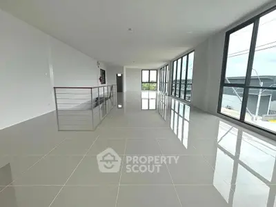 Spacious modern interior with large windows and glossy tiled floors, perfect for versatile living or office space.