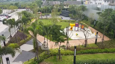 Spacious garden with playground in a modern residential complex, ideal for family living.