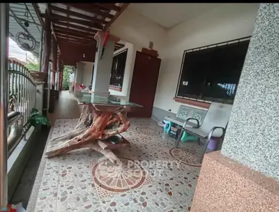 Charming outdoor patio with rustic wooden table and decorative tiled flooring.